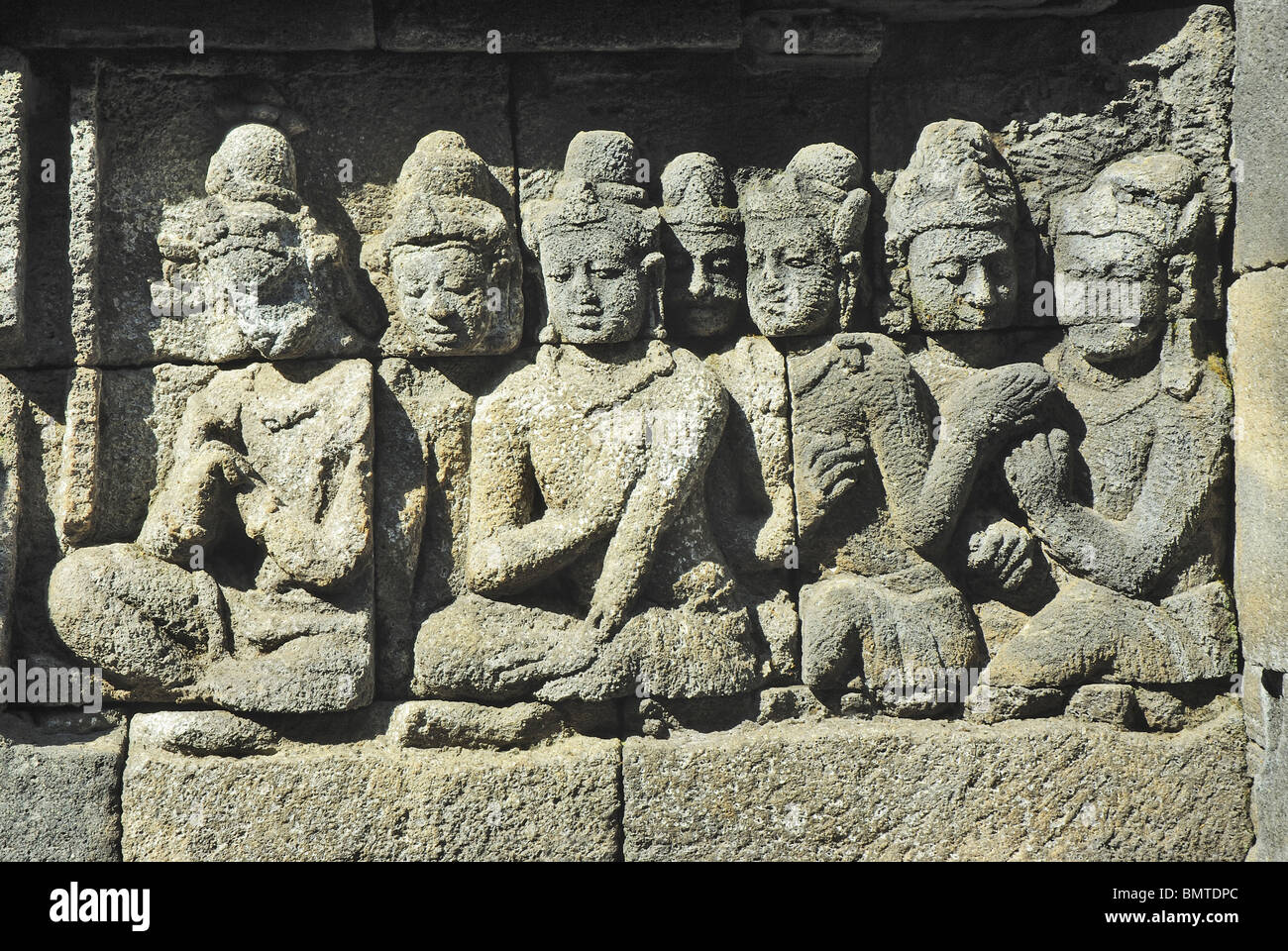 Indonesia-Java, Borobudur, devotos sentado delante del Señor Buda (no en la foto). Foto de stock
