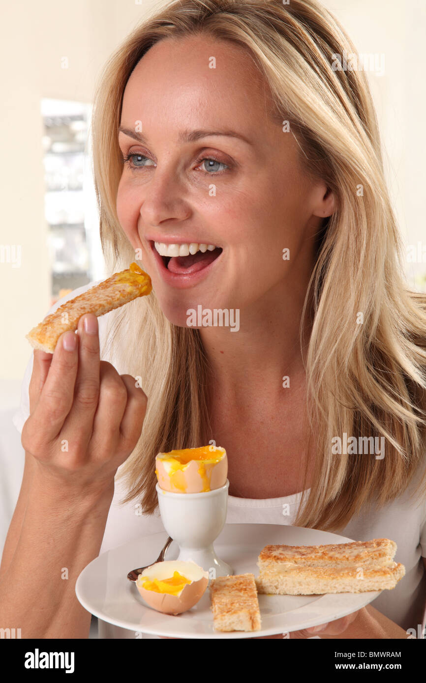 Mujer comiendo un huevo hervido Foto de stock