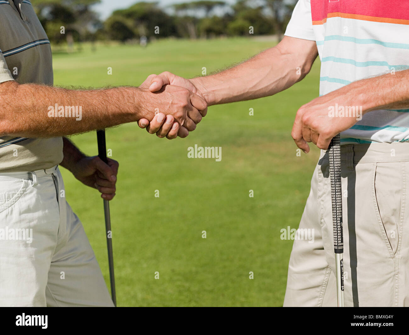 Dos hombres maduros agitando las manos en el campo de golf Foto de stock
