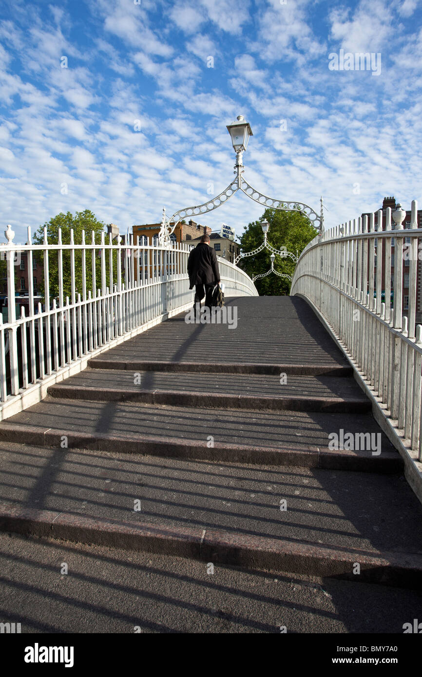Hombre en un traje de Ha'Penny cruzando el puente que cruza el río Liffey en Dublín la capital irlandesa Foto de stock