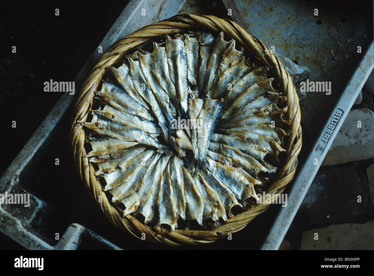 En un mercado de Algarve sardinas secas son artísticamente dispuestas en círculo en una canasta redonda Foto de stock