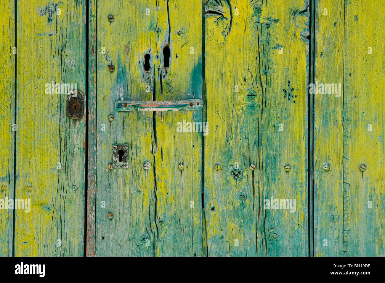 Detalle de una rústica puerta de madera verde y amarillo Foto de stock