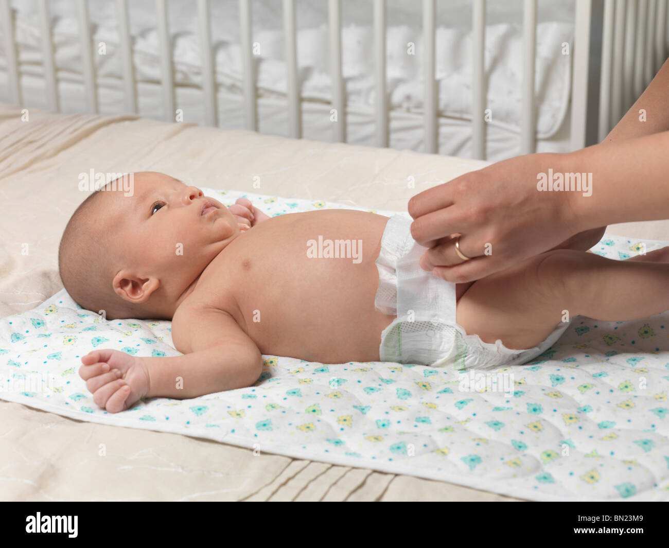 Seis Semanas De Edad Lindo Bebé Niño Acostado En Una Cama Mientras La Madre Está Cambiando El 1801