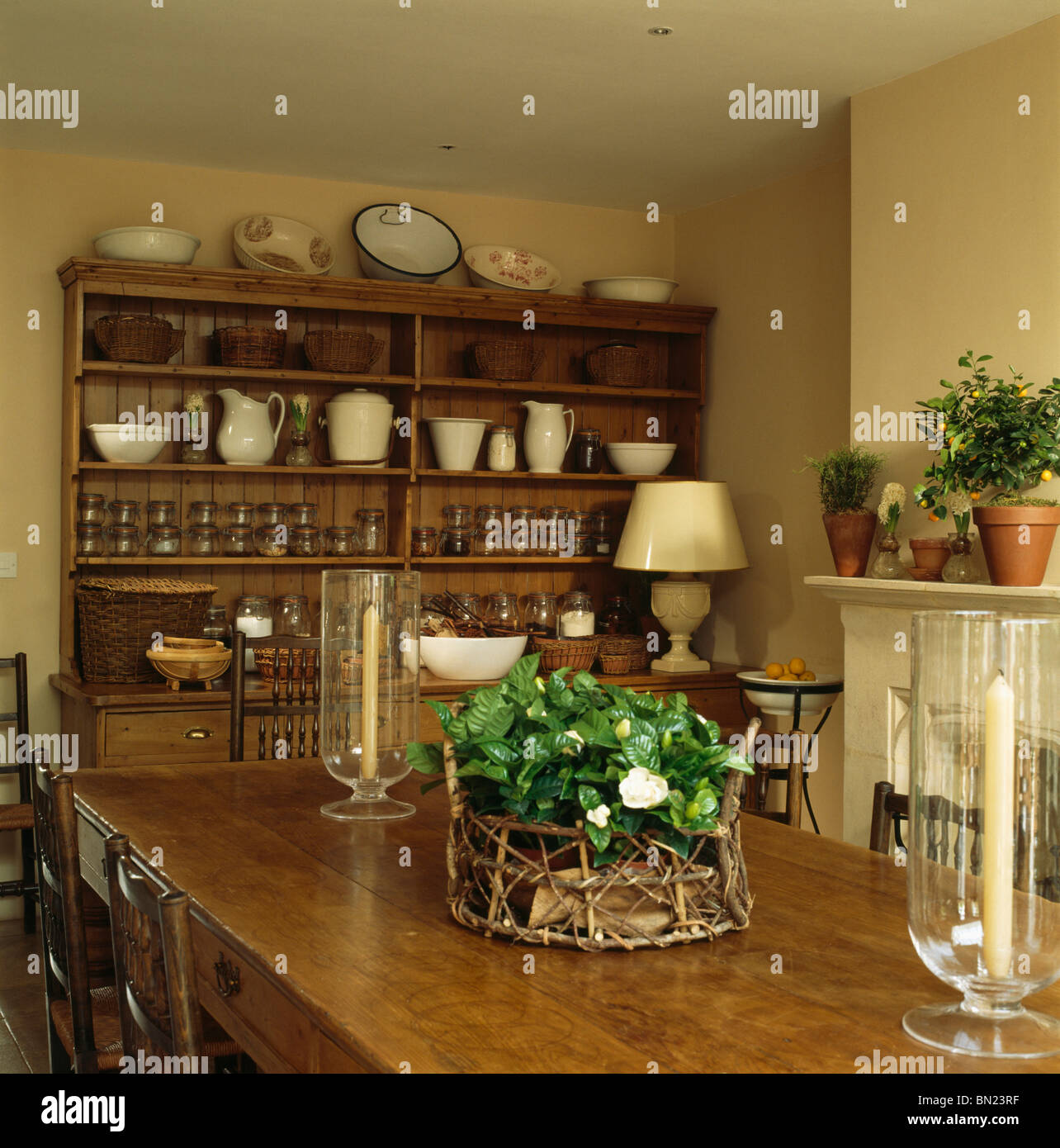 En Houseplant cesta y faroles de cristal sobre la mesa de madera en comedor  con resquebrajarse jarras en gran aparador Fotografía de stock - Alamy