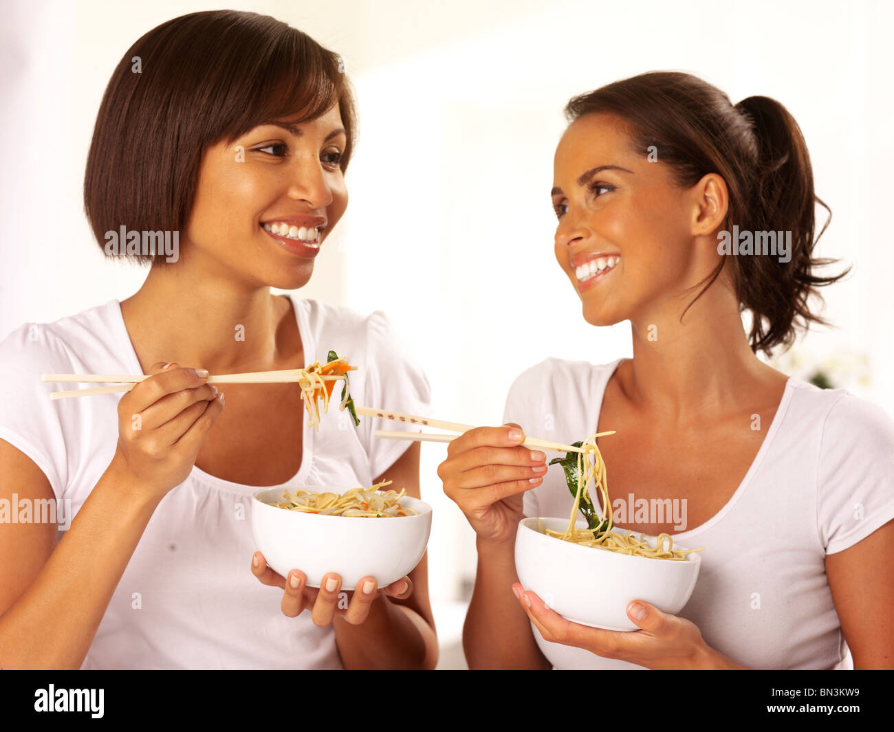 Dos mujeres comiendo fideos Foto de stock