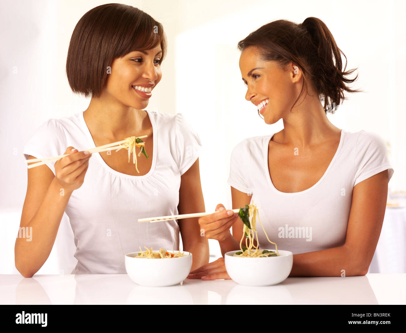 Dos mujeres comiendo fideos Foto de stock