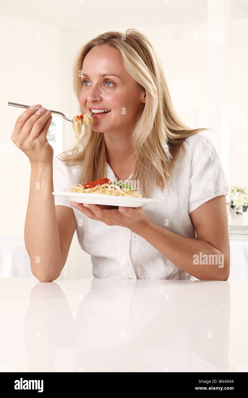 Mujer comer pasta Foto de stock