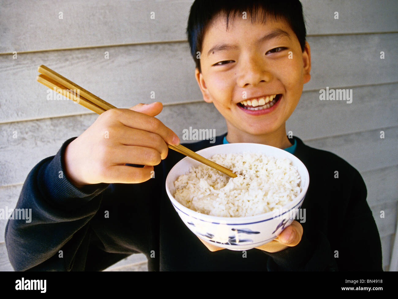 Niño chino de comer con palillos de cuenco de arroz Fotografía de stock -  Alamy