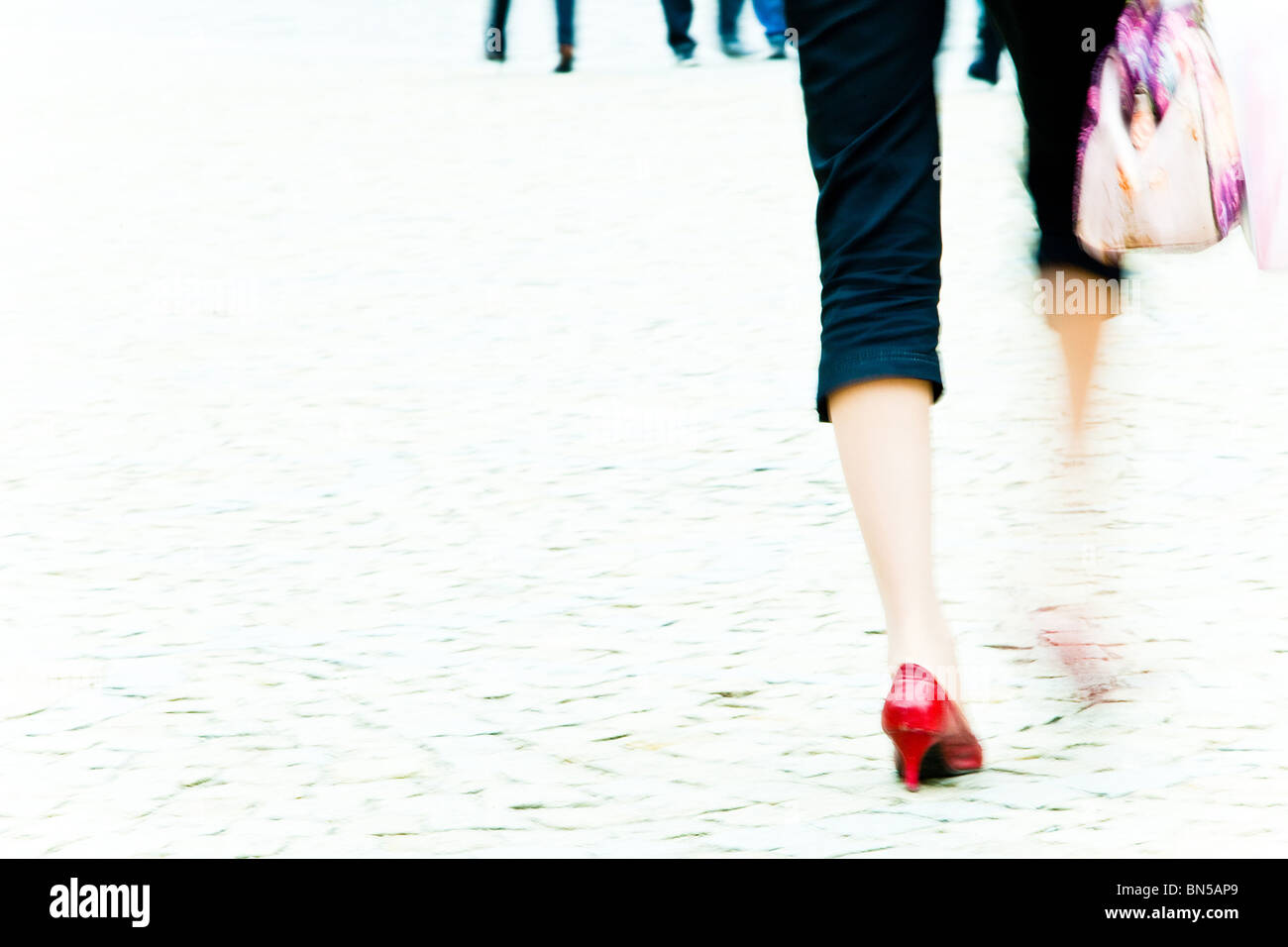 Mujer caminando en tacones de aguja roja sobre el pavimento - motion blur Foto de stock