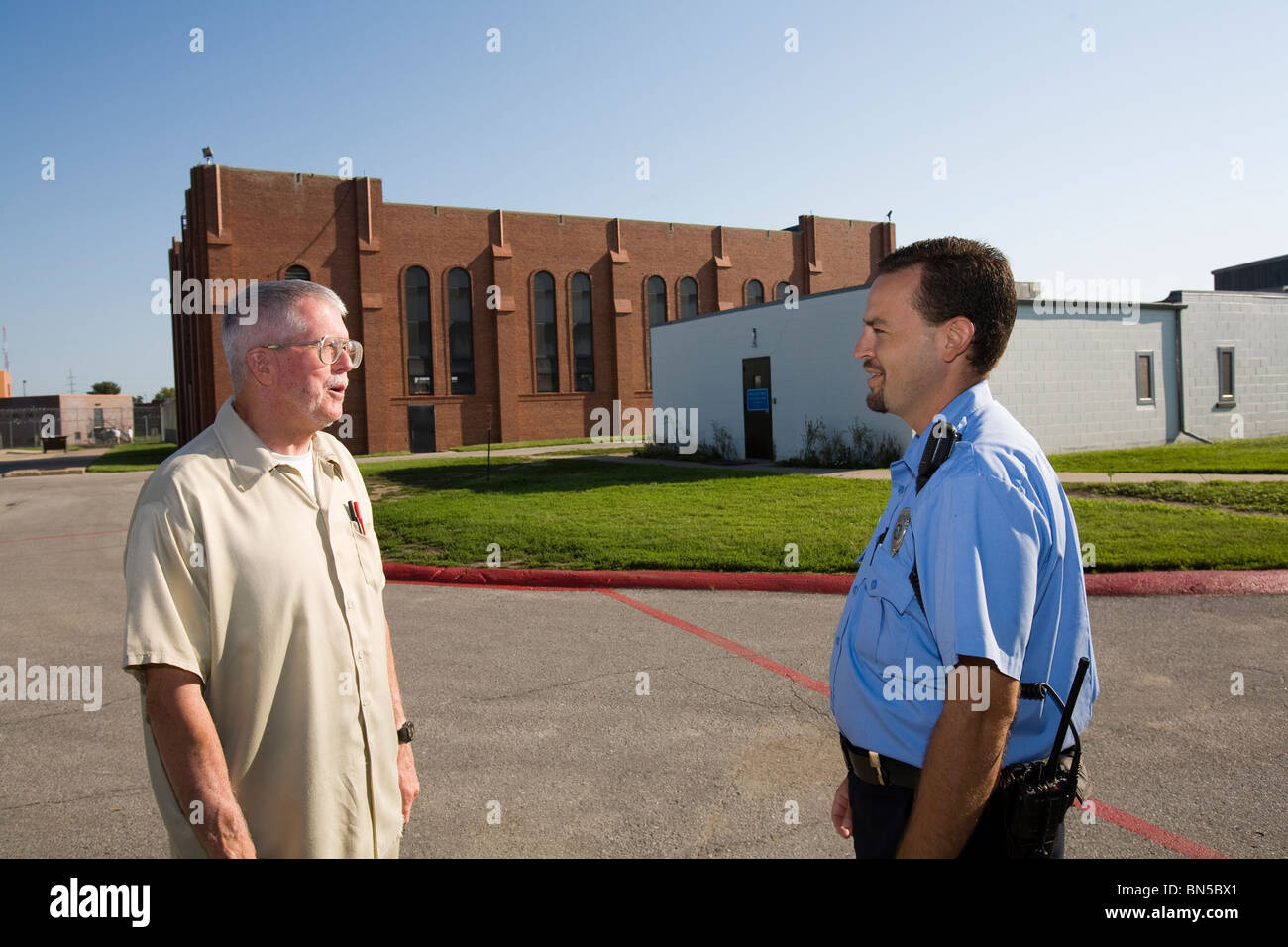 Funcionario Correccional y el recluso hablando en el patio. La Penitenciaría del Estado de Nebraska, en Lincoln, Nebraska, EEUU. Foto de stock