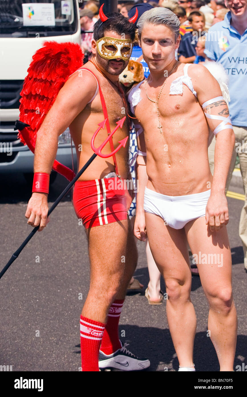 Desfile del orgullo gay de Londres , dos bare encabezaron jóvenes o niños ,  Pareja , en shorts plantean en Diablo & angel disfraces Fotografía de stock  - Alamy