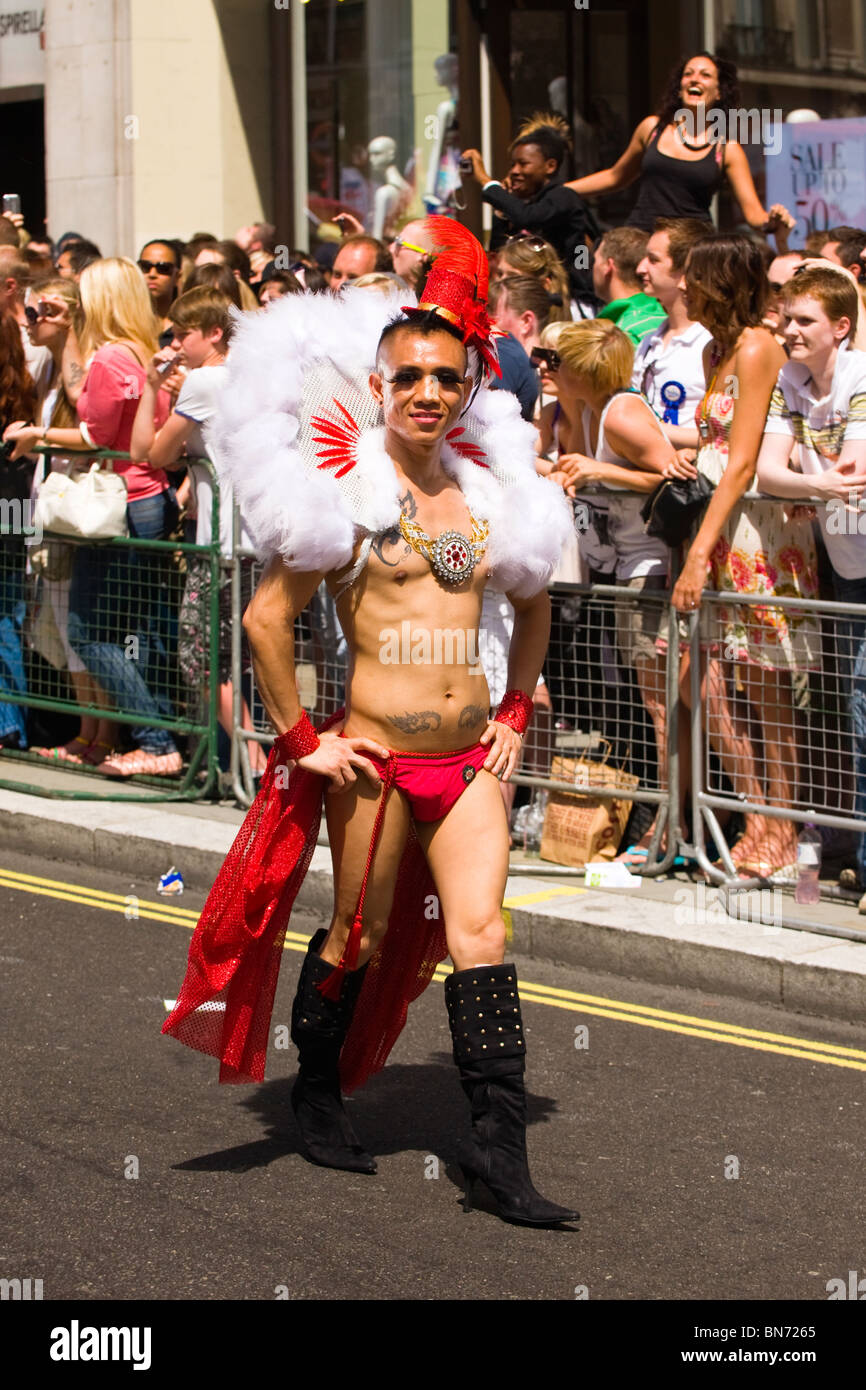 Desfile del orgullo gay de Londres , joven o muchacho en exóticos disfraces  de carnaval de plumaje blanco y rojo sinopsis y sombrero y botas negras  Fotografía de stock - Alamy