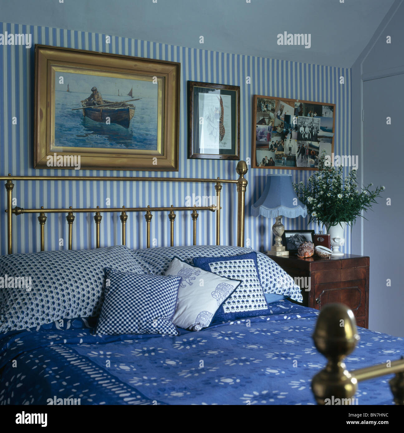 Las fotografías sobre cama de latón con blue+cojines blancos y la cama en  el dormitorio cubierta azul con rayas blancas+papel tapiz Fotografía de  stock - Alamy