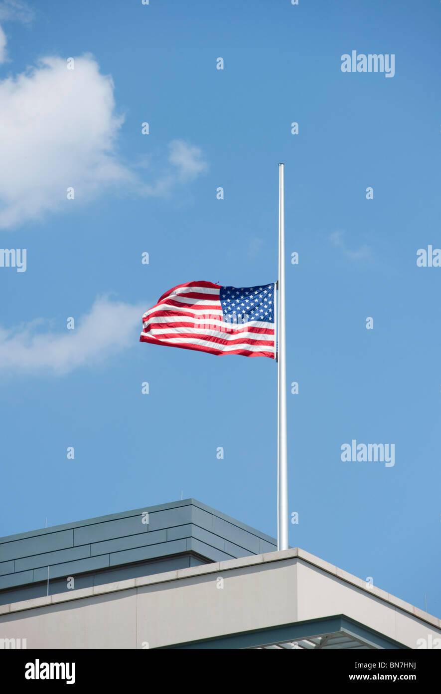 Estados Unidos de América bandera ondeando a media asta arriba de la embajada estadounidense en Berlín, Alemania Foto de stock