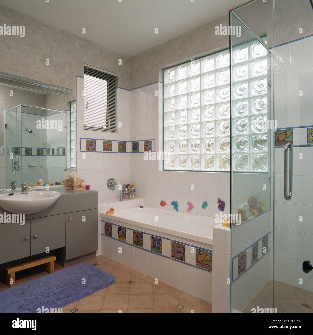Ventana de ladrillo de vidrio sobre la bañera, con decoración de azulejos  en el baño de la familia moderna Fotografía de stock - Alamy