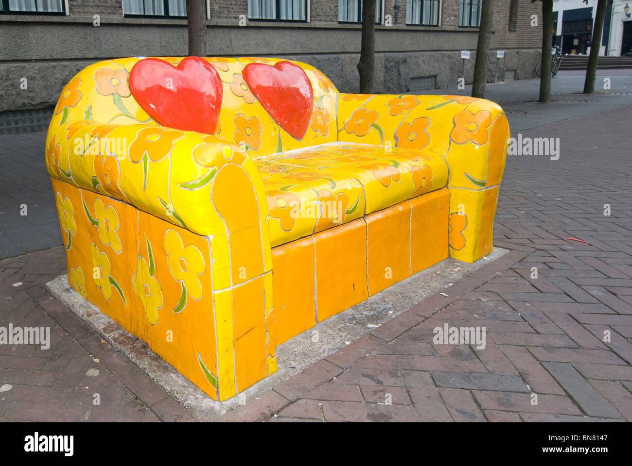 Sofá cama con azulejos de piedra de la calle flores amarillas de Amsterdam  Holanda banco de arte Fotografía de stock - Alamy
