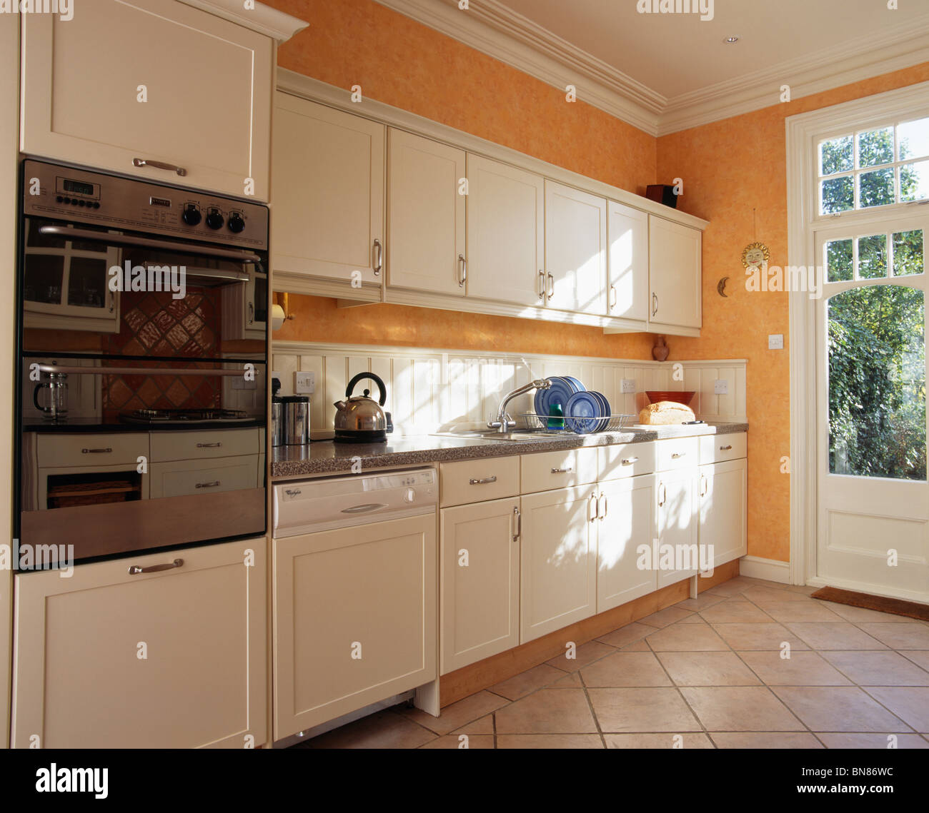 A nivel de los ojos en la moderna cocina horno naranja con blanco provisto  de unidades y equipado lavavajillas Fotografía de stock - Alamy