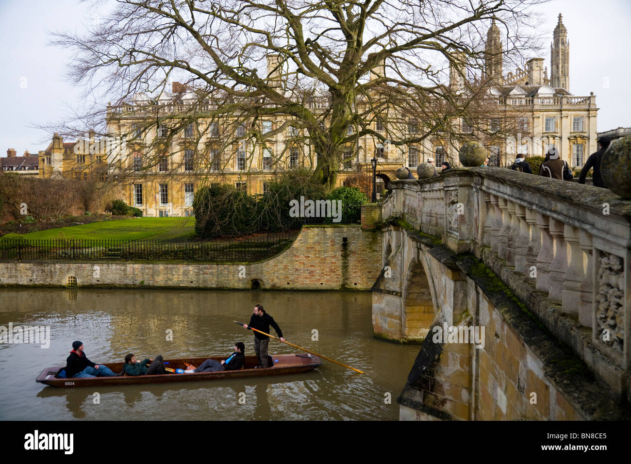 Los estudiantes punt / navegar en el río Cam y la fachada oeste de Clare College, de la Universidad de Cambridge. Visto desde la espalda. En el Reino Unido. Foto de stock