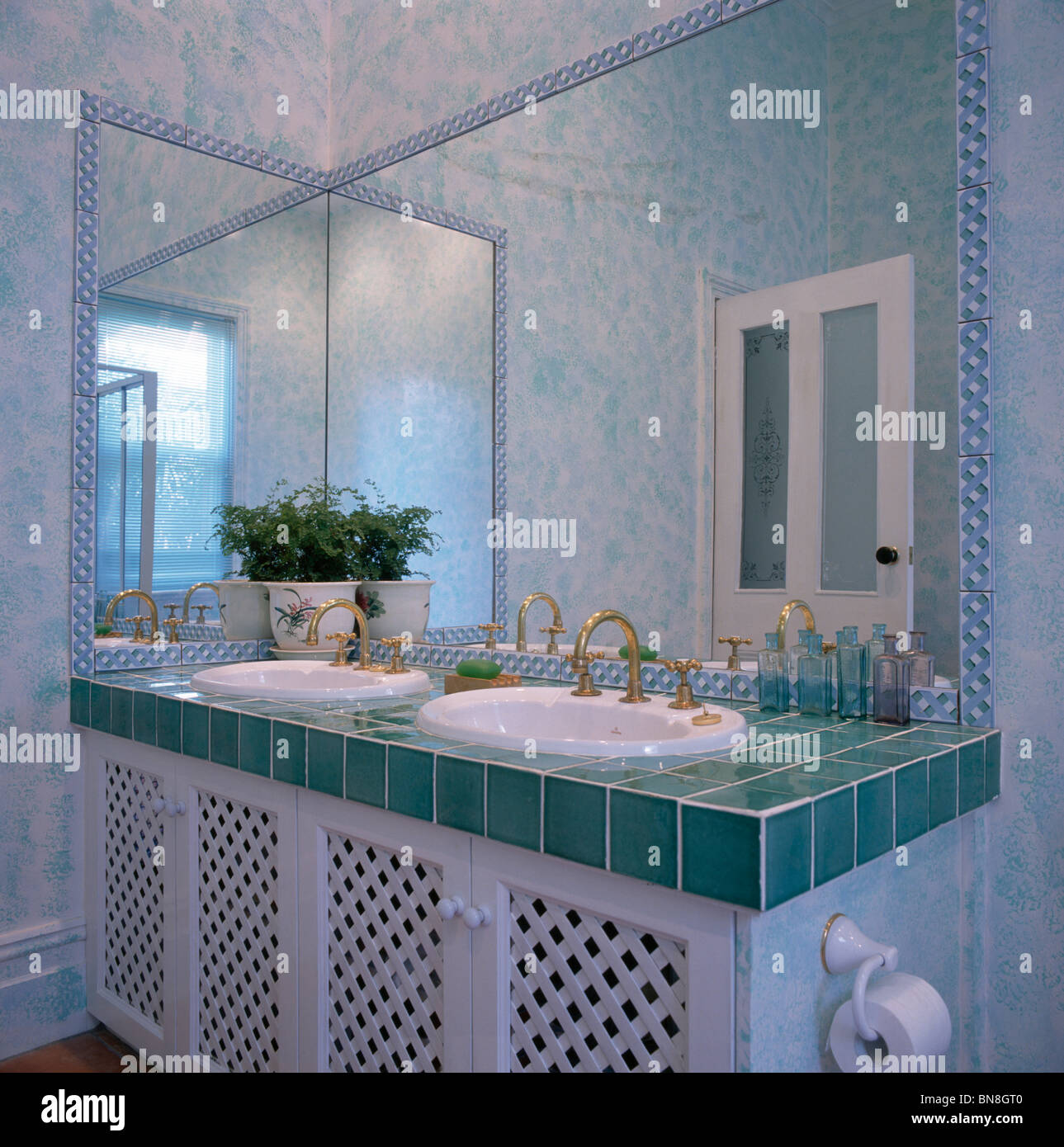 Espejo sobre lavabos dobles en vanity unidad con encimera de azulejos de  color turquesa en el moderno cuarto de baño con paredes de efecto esponja  Fotografía de stock - Alamy