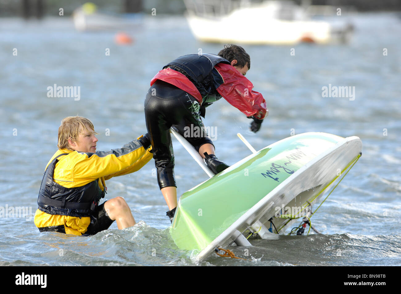 Dos muchachos adrizar un láser yacht después del naufragio en 18 nudos de  viento en el río Hamble. Reino Unido Fotografía de stock - Alamy