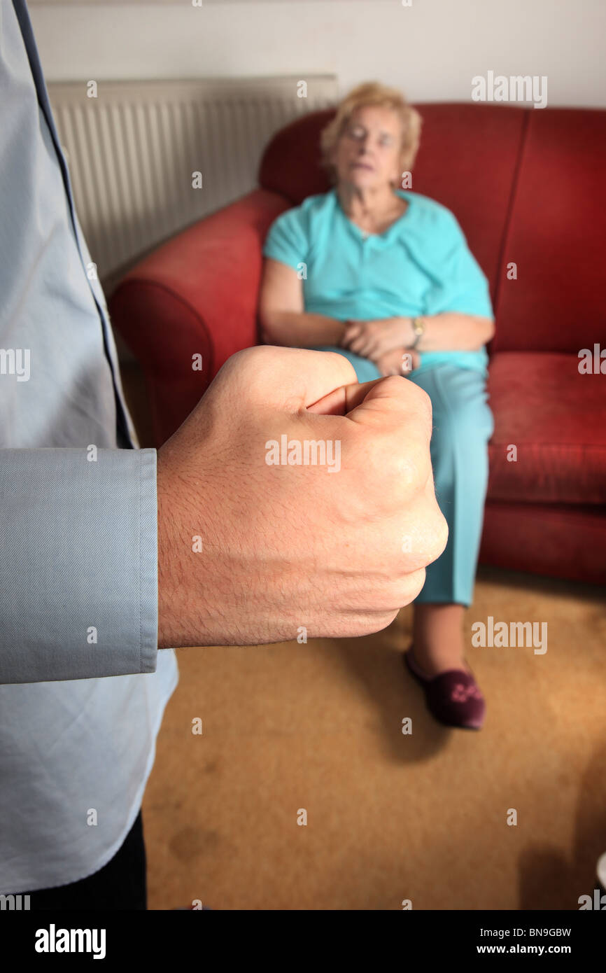 Clenched puño del hombre como anciana duerme en un sofá Foto de stock
