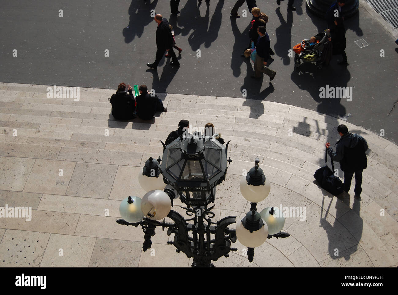 Las parejas sentada en los escalones de L'Opera por debajo de una lámpara ornamental estándar número 2913 Foto de stock