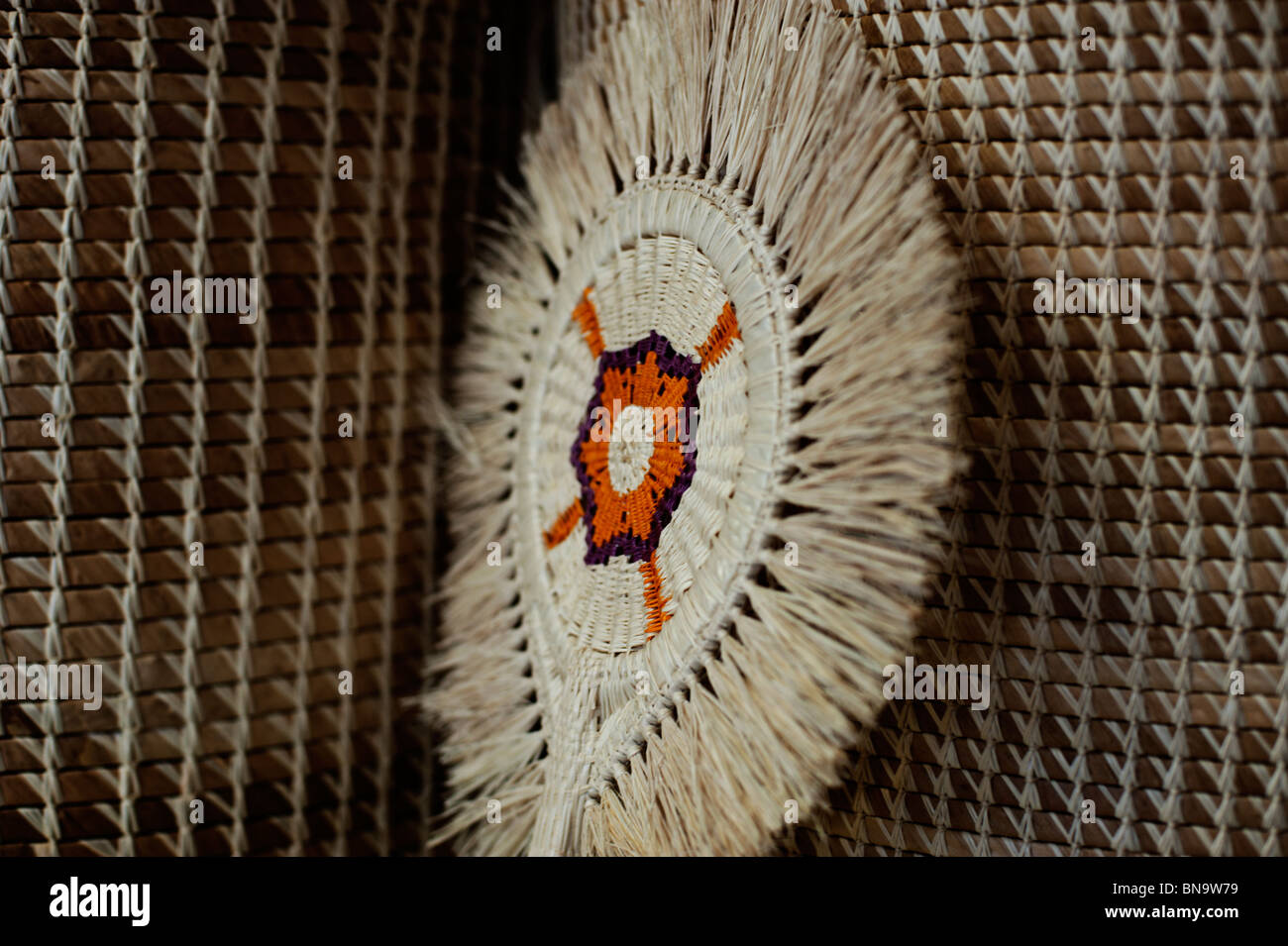 Un ventilador tradicional, tejida a partir de fibras naturales, descansa contra dos cestas en una tienda de artesanía en las Islas Marshall. Foto de stock