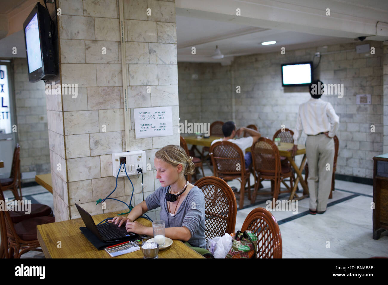 Un turista extranjero con un portátil en un restaurante de hotel en Delhi, India. Foto de stock
