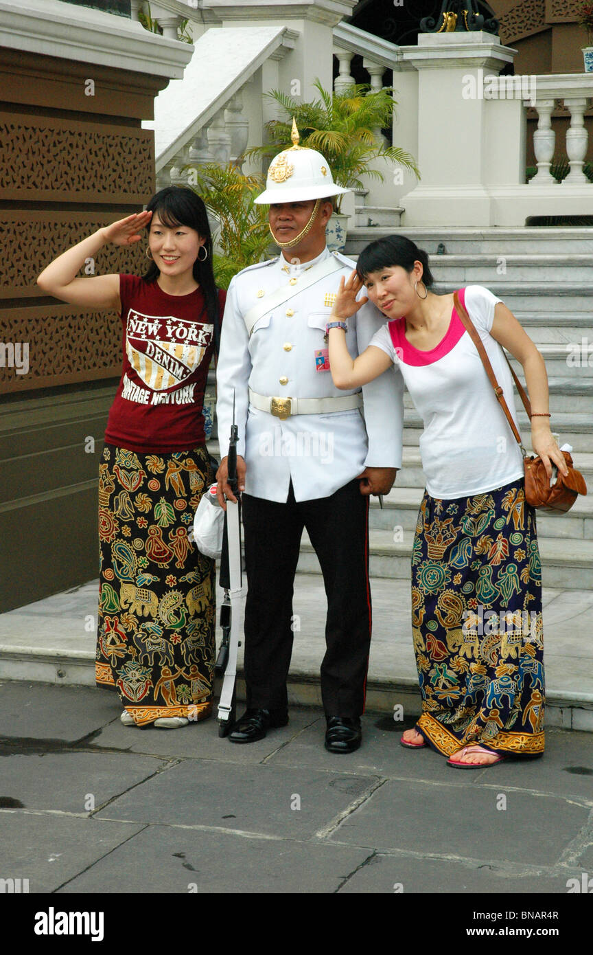 El buen humor Guardia real plantea con los visitantes del Grand Palace Bangkok Thailand Foto de stock