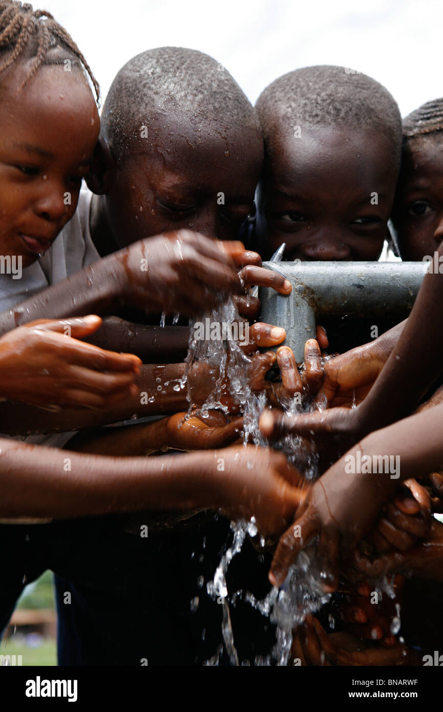 Los niños beben agua de Sierra Leona Foto de stock