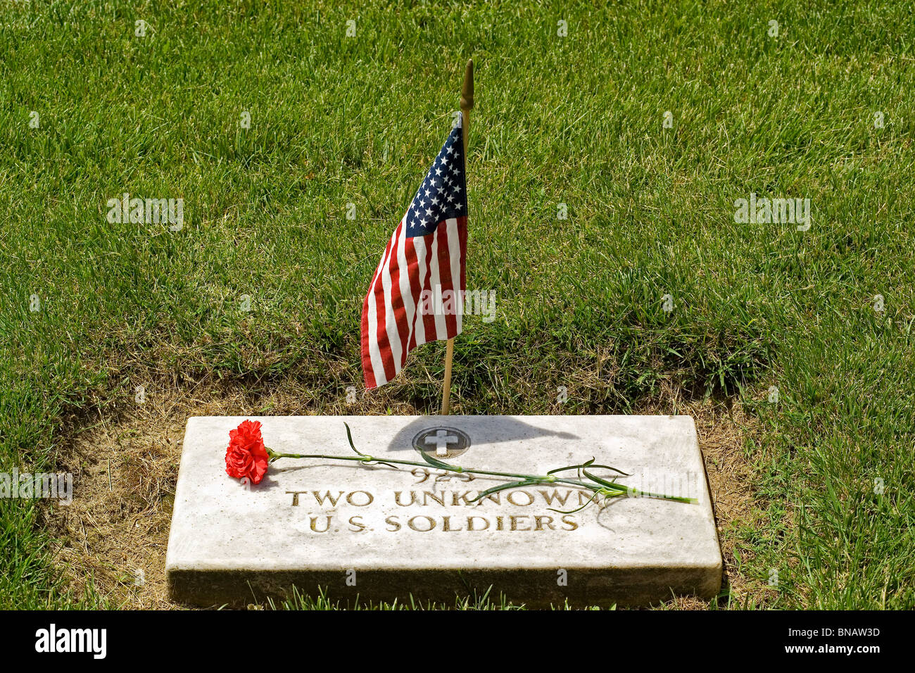 Una bandera americana y una flor honor las tumbas de dos soldados estadounidenses desconocido de la Guerra Civil en el Cementerio Nacional de Yorktown en Yorktown, Virginia, EE.UU. Foto de stock