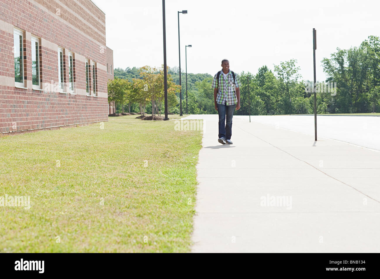 Estudiante de la escuela secundaria masculina caminando por la escuela Foto de stock