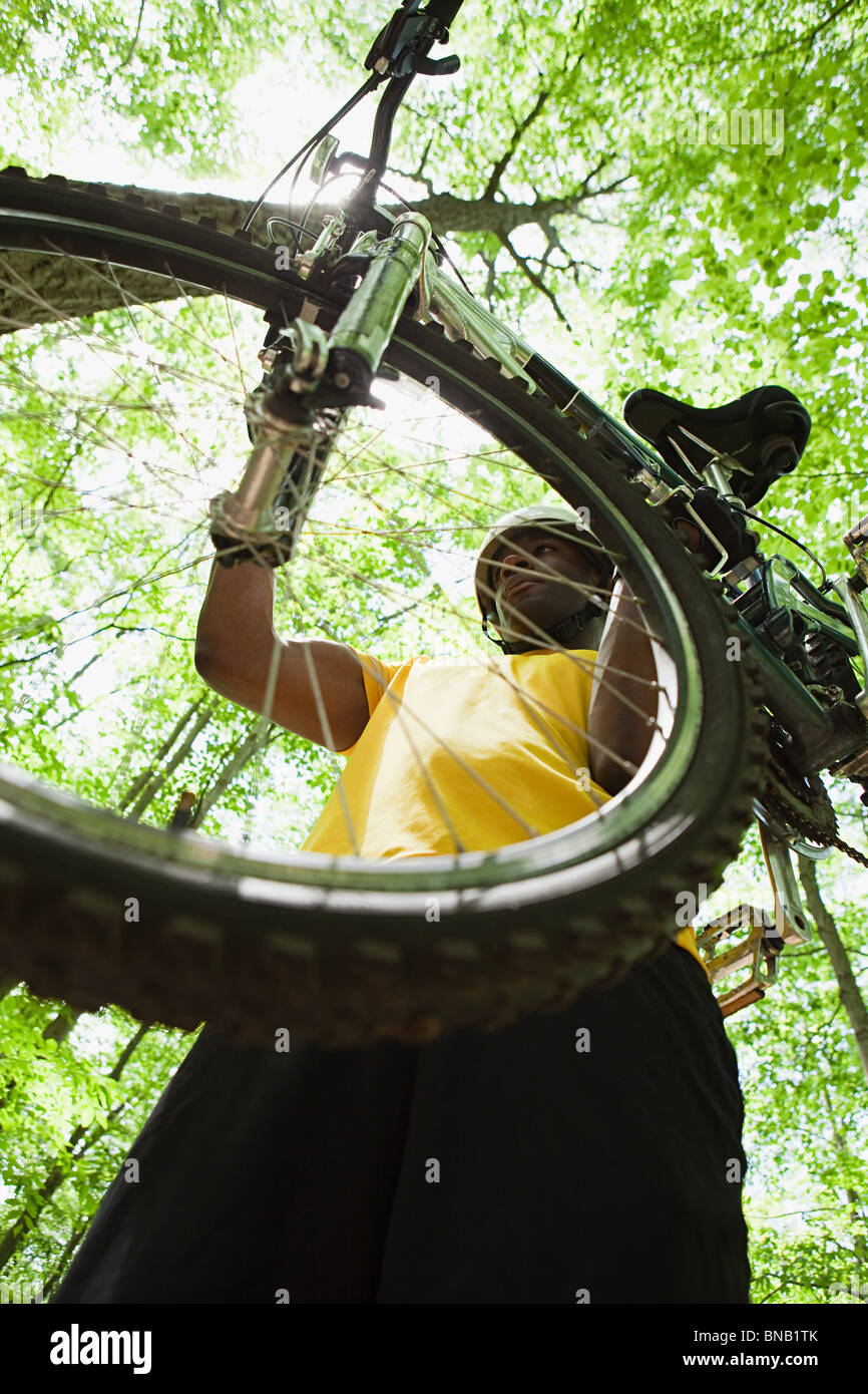 Ciclista llevar bicicletas en bosque Foto de stock