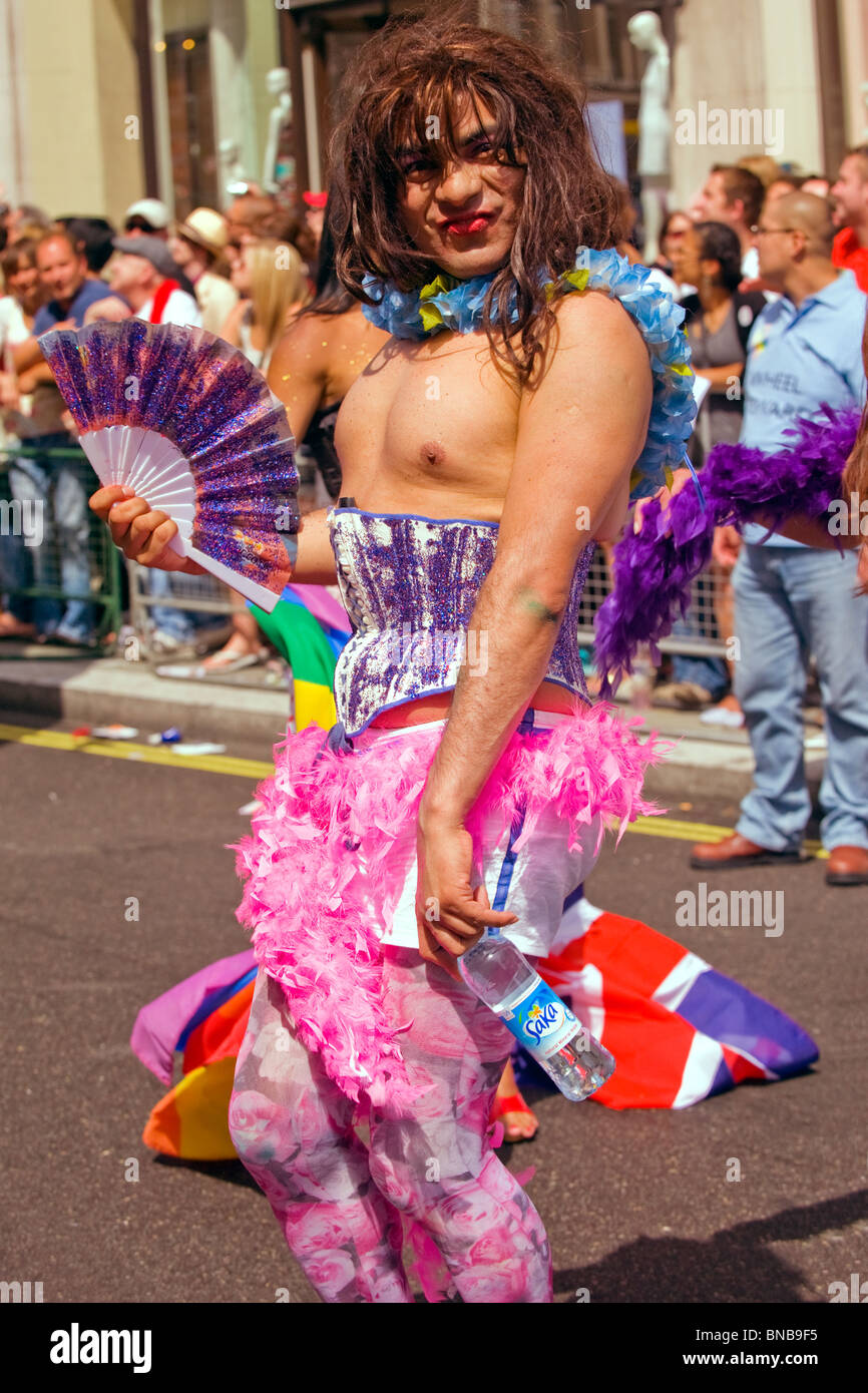 Orgullo Gay de Londres , guapo joven sonriente o muchacho en el maquillaje  & Purple corpiño , rosa panties & pluma rosa boa Fotografía de stock - Alamy