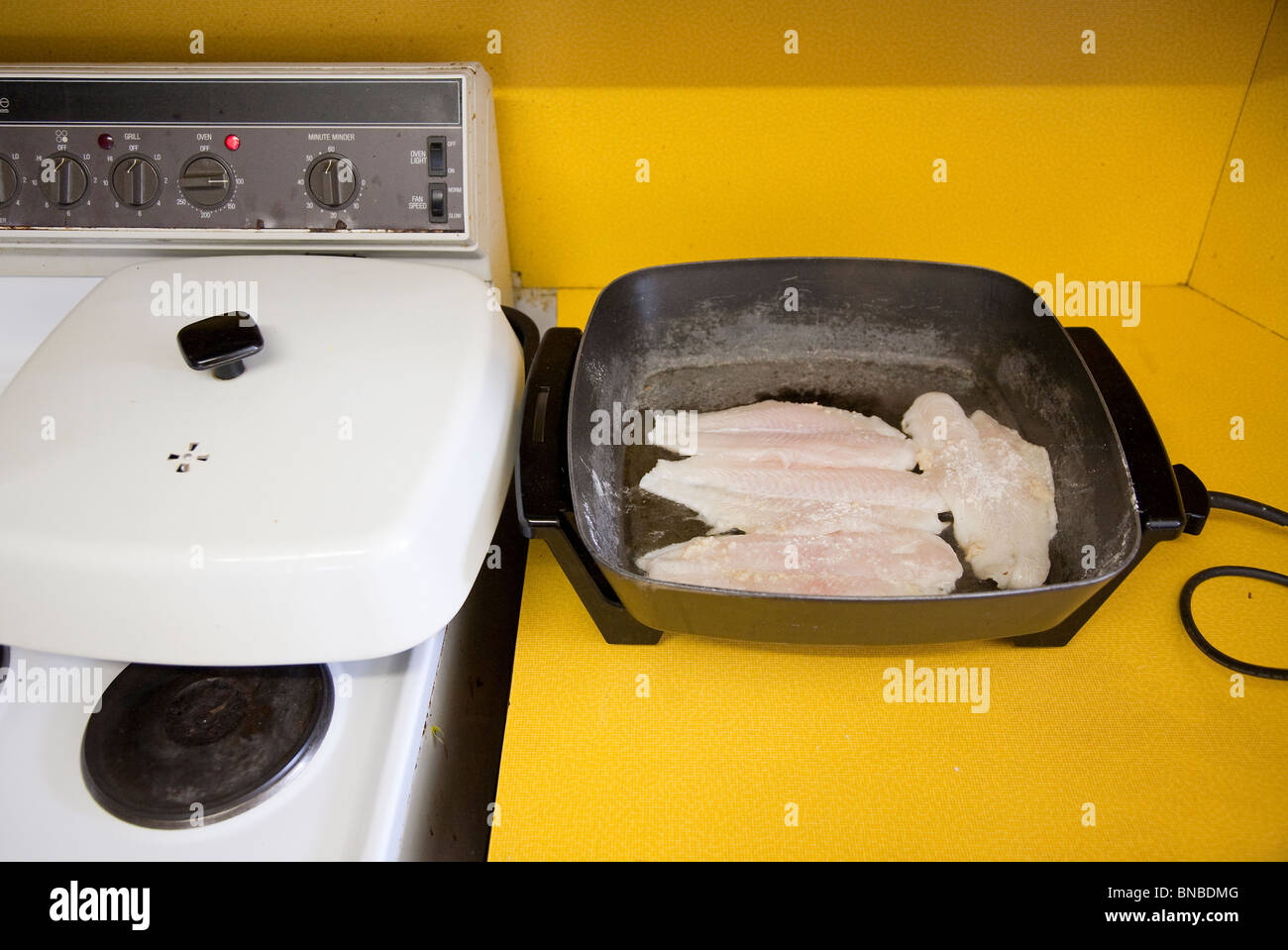 Patatas fritas de pescado en una sartén eléctrica en una antigua cocina  Fotografía de stock - Alamy