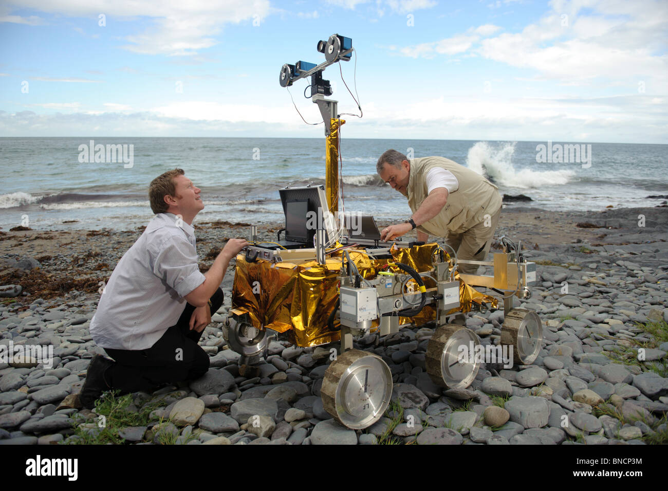 Lester Waugh de EADS Astrium y el Dr. Stephen Pugh de Aberystwyth University con el Mars Rover mock-up en la playa Gales UK Foto de stock