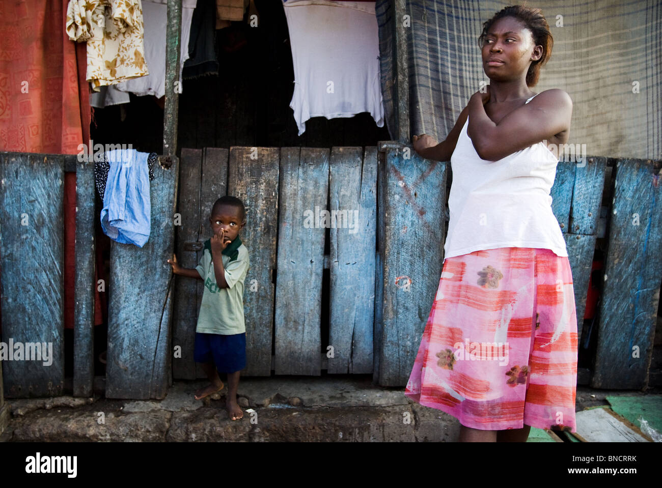 Una mujer y su hijo frente a su casa en Accra, Ghana. Foto de stock