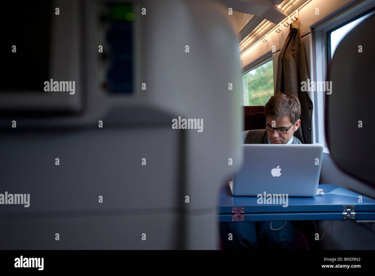 Empresario trabajando en el portátil en carro de primera clase en alemán express tren de alta velocidad ICE Foto de stock