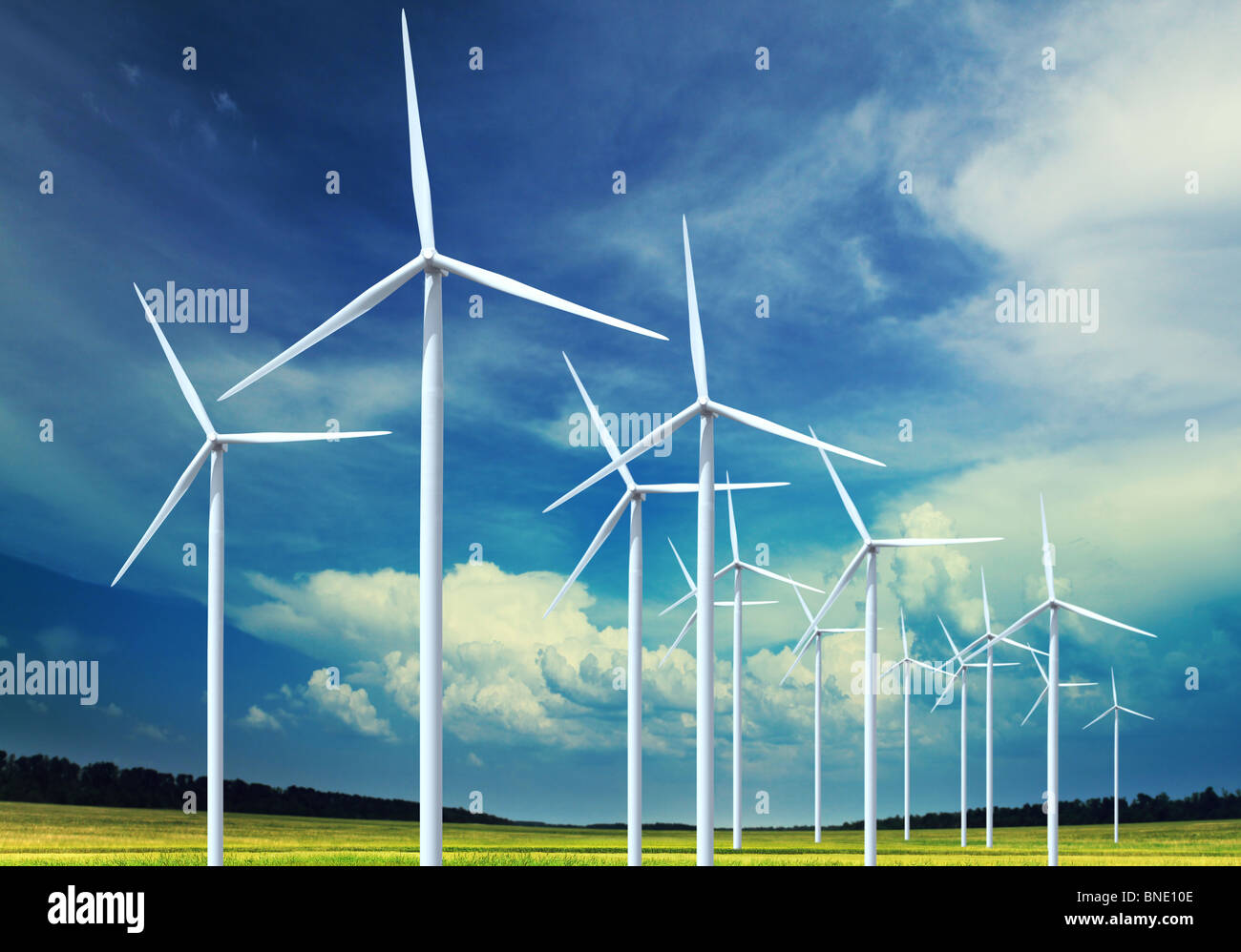 Hermoso y verde pradera con turbinas eólicas generadoras de electricidad Foto de stock