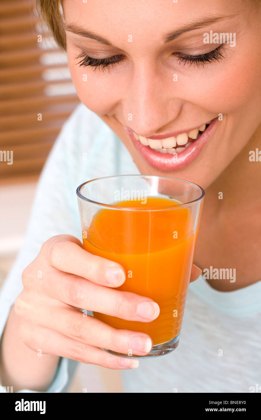 Hermosa joven beber jugo de naranja cerrar Foto de stock