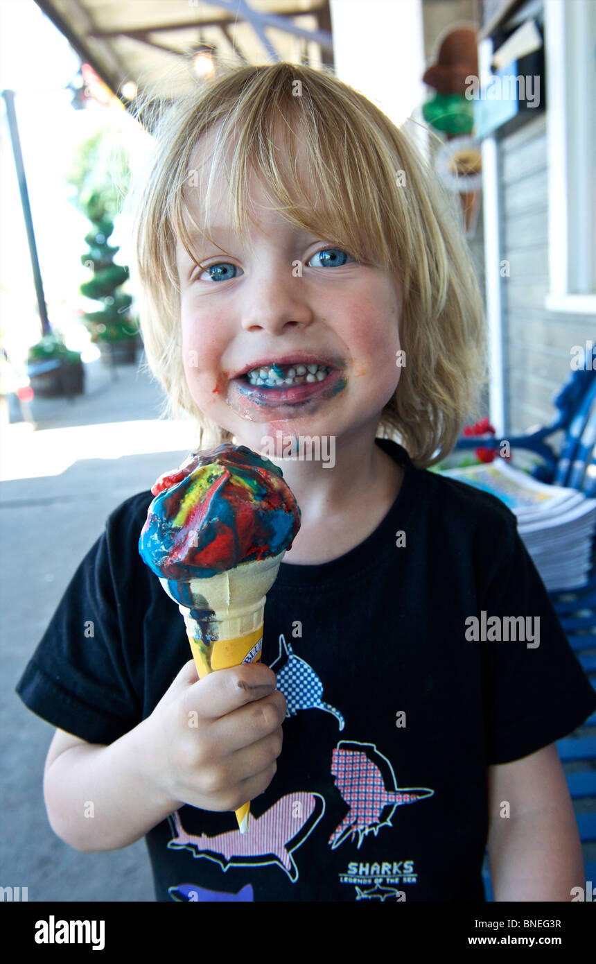 Joven comiendo un helado multicolor, con montones de agentes colorantes, EE.UU. Foto de stock