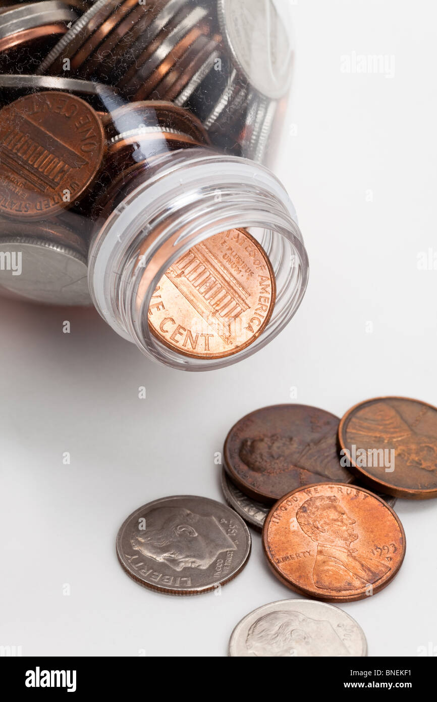 Botella de plástico y monedas,Dólar con fondo blanco. Foto de stock
