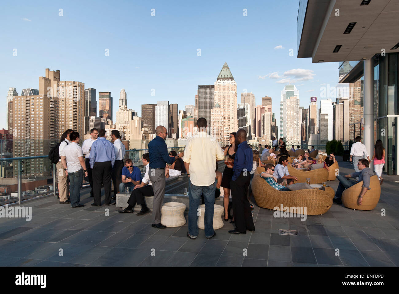 Diversos grupos de jóvenes neoyorquinos socializar beber y disfrutar de las fantásticas vistas panorámicas de Manhattan desde la tinta de impresión 48 Hotel Rooftop Bar Foto de stock