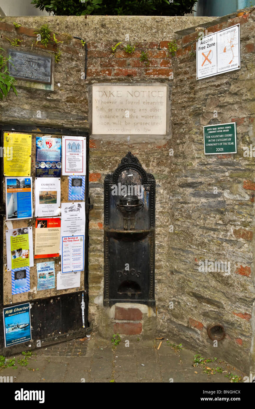 Un nicho en una pared con una bomba antigua ciudad y avisos en Salcombe, Sur de jamones, Devon Foto de stock