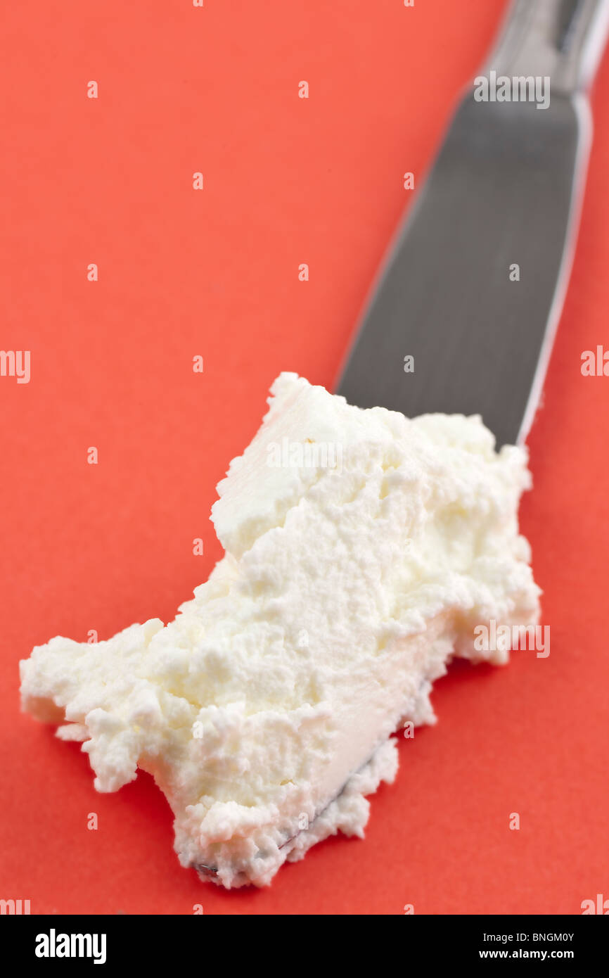 Llena de cuchilla con una porción de Quark libre de grasa de crema de queso blanco Foto de stock