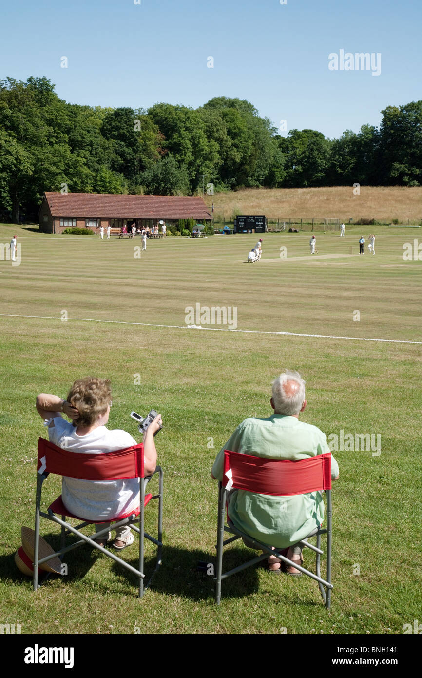 Un par ver un partido de cricket de aldea en la aldea de Lyminge cerca de Folkestone, Kent, UK Foto de stock
