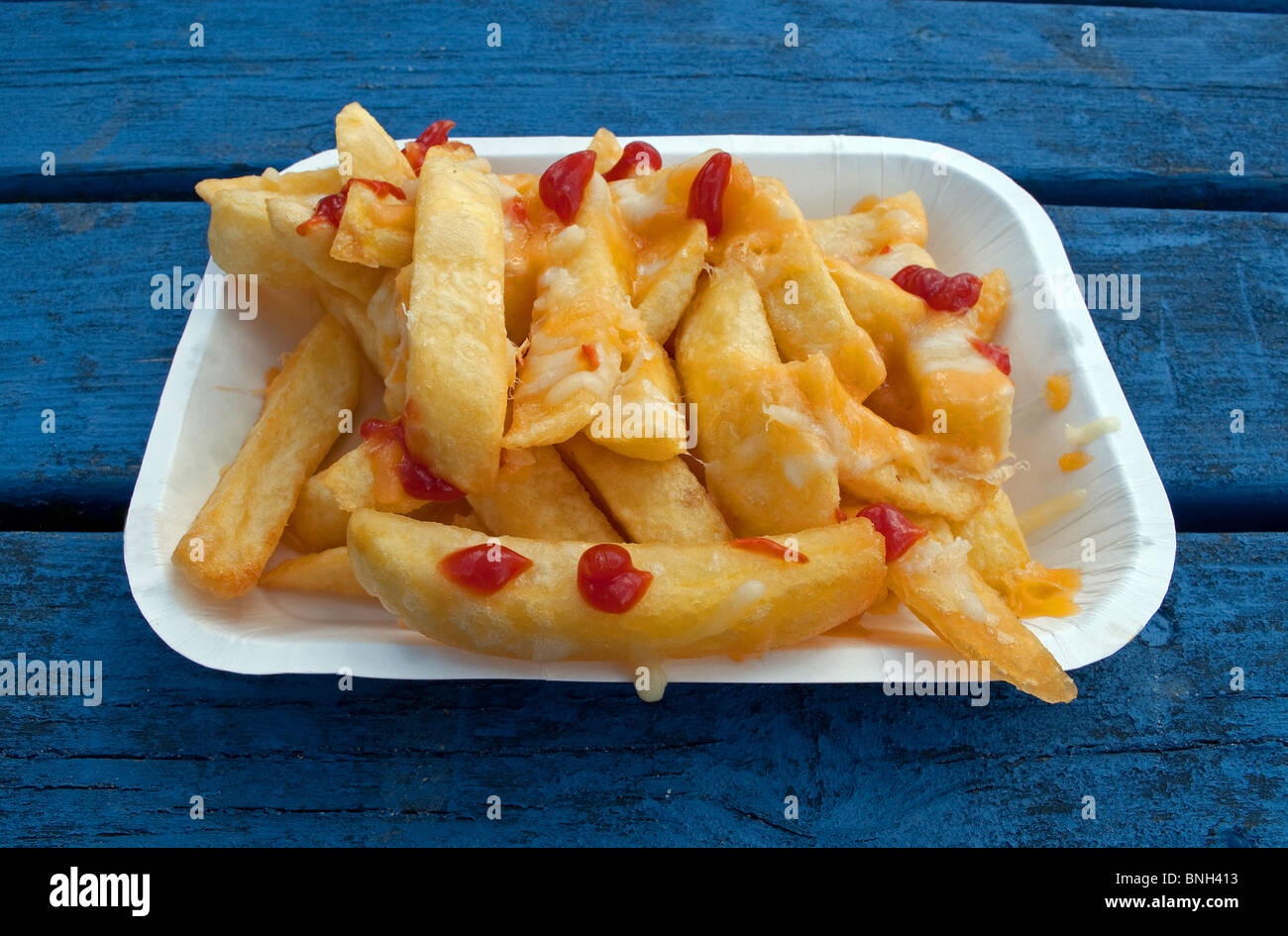 Una bandeja de chips fritos con la salsa de tomate ketchup sobre ellas Foto de stock