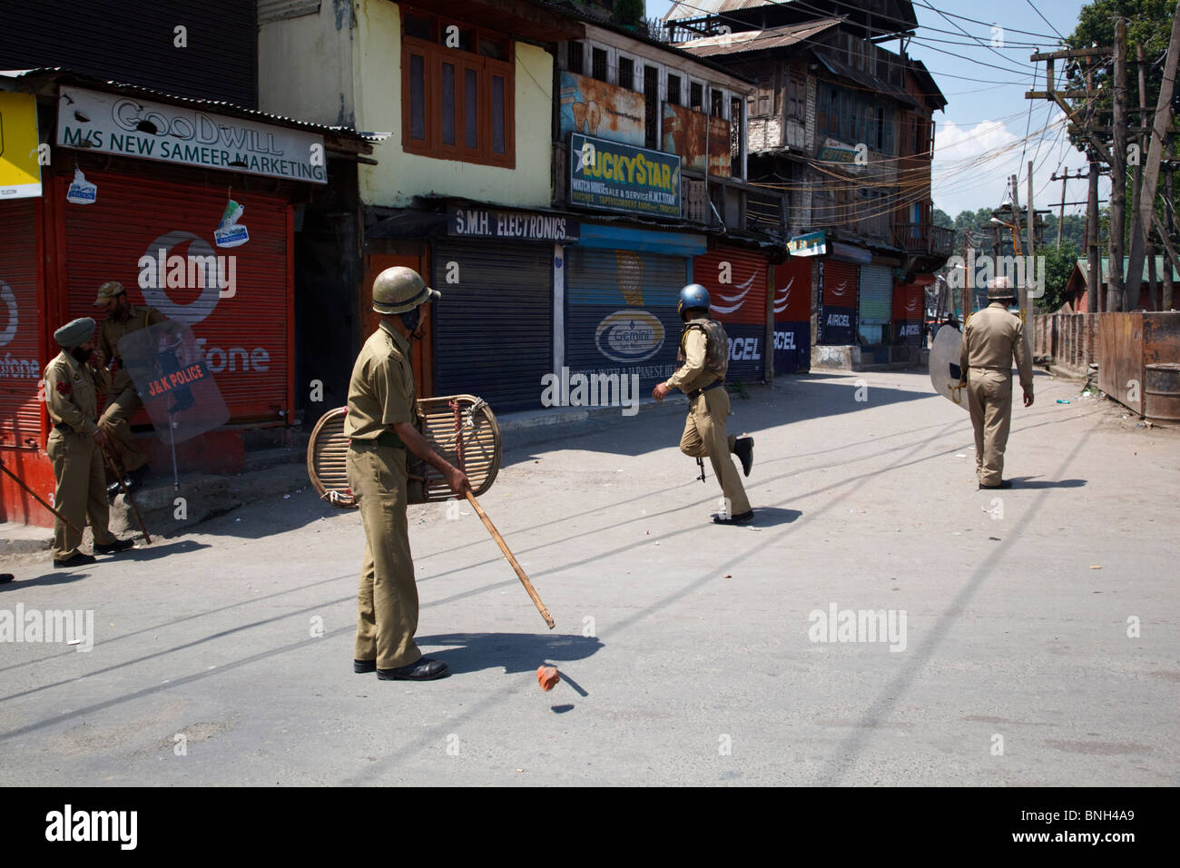 La policía peleas con adolescentes arrojando piedras contra ellos durante los disturbios en Srinagar, Jammu y Cachemira, en la India. Foto de stock