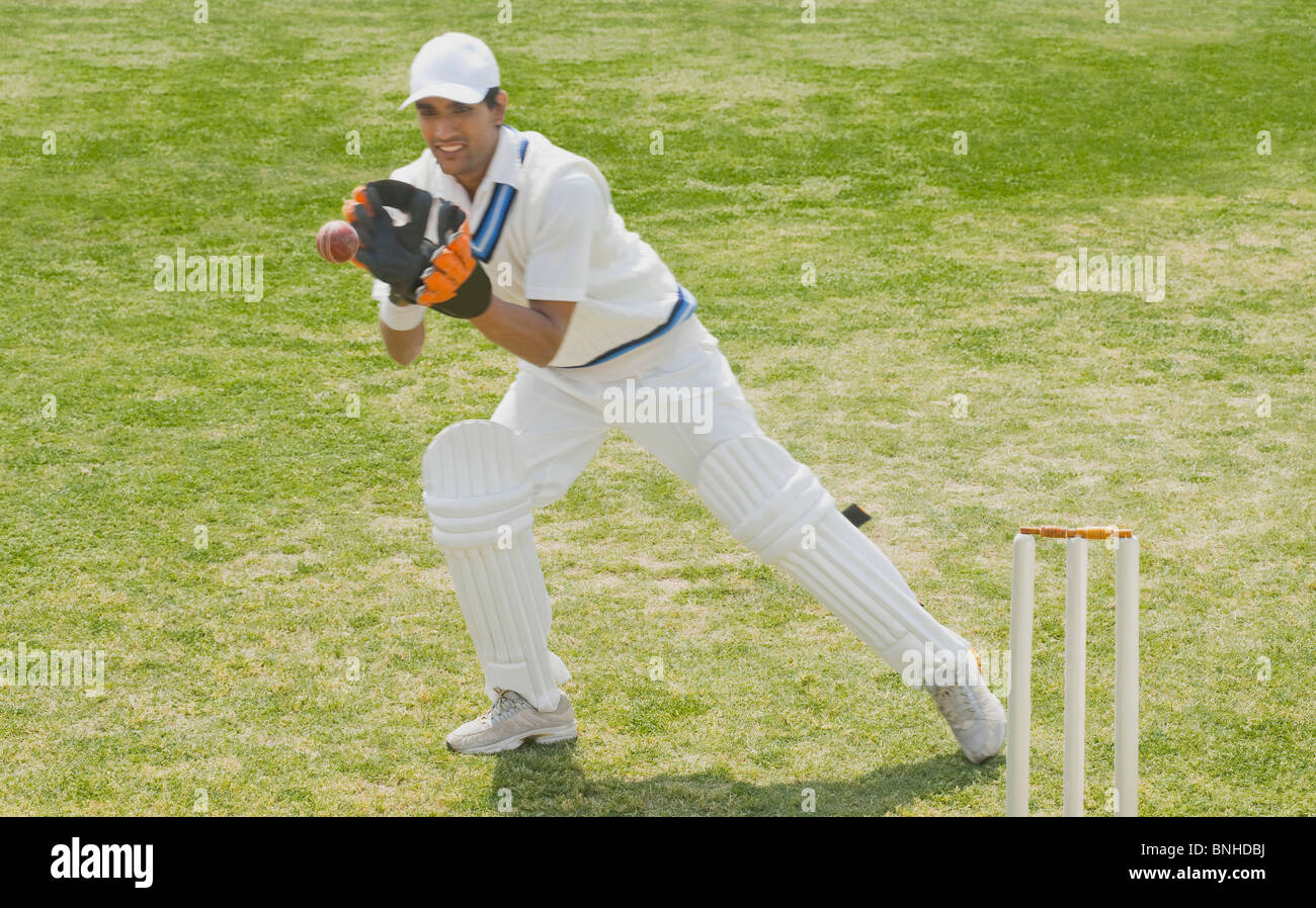 Cricket wicketkeeper agarrar una pelota detrás de tocones Fotografía de ...