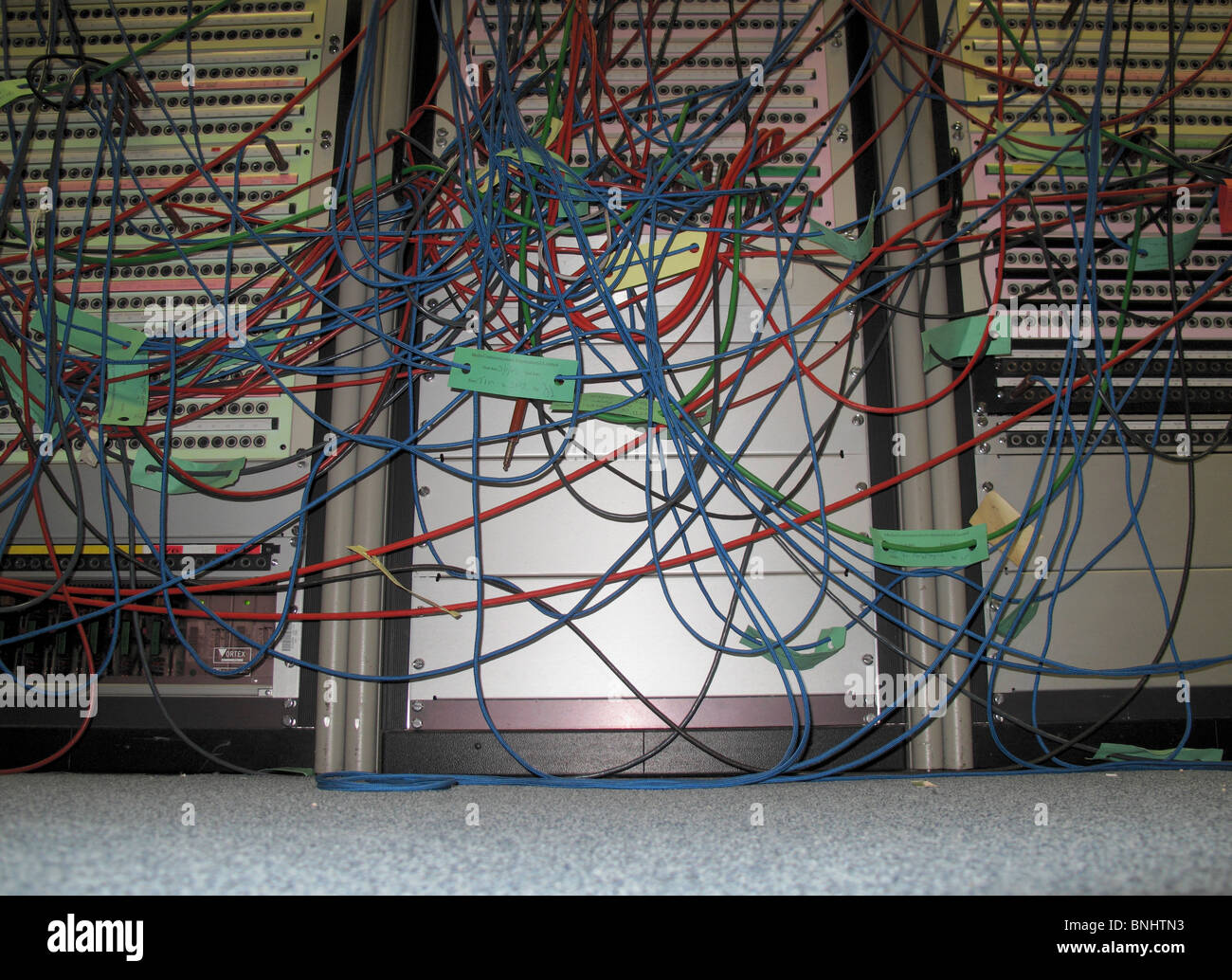 Masa de cables rojos y azules procedentes de los servidores montados en rack Foto de stock